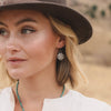 A model wearing the southwest stamped silver sun cross earrings