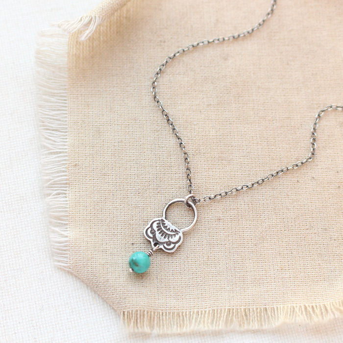 The turquoise jolie necklace styled on tan linen